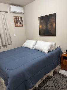 a bedroom with a bed with a blue blanket at Apartamento perto do centro da Cidade in Campo Grande