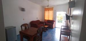 a living room with a table and chairs and a couch at Apartamentos grigri in Río San Juan