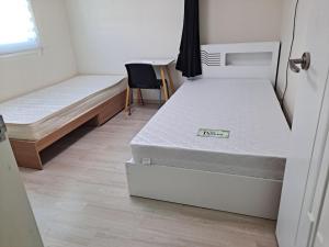 a room with two beds and a desk and a chair at 인천인하우스 
