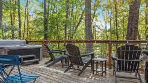 three chairs and a grill on a deck with trees at Wooded Nest, Cozy 3BR Chalet Near Spas, Downtown Berkeley Springs & Hiking in Berkeley Springs
