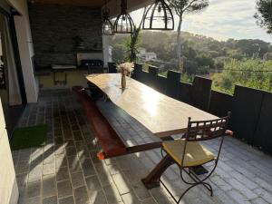 a wooden table and a chair on a patio at Villa Le M in Six-Fours-les-Plages