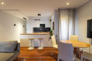 a kitchen and living room with a table and a couch at New Bilbao city center in Bilbao
