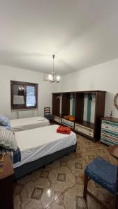 Un dormitorio grande con dos camas y una mesa. en B&B Angelo e Graziella, en Monterosi