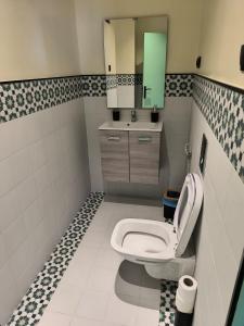 Un baño con inodoro, lavabo y espejo. en YaYaCaSa, en Tánger