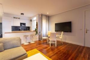 a living room with a couch and a table with chairs at New Bilbao city center in Bilbao