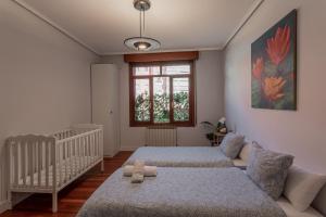 a bedroom with two beds and a baby crib at New Bilbao city center in Bilbao