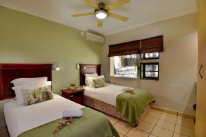 Postel nebo postele na pokoji v ubytování Ngwenya Lodge