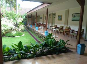un ristorante con tavoli e sedie in un cortile di Hotel Besar Purwokerto a Purwokerto