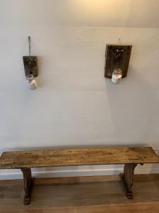 a wooden bench in front of a wall with two lights at I CARCIONI Infinity Pool in Belgirate