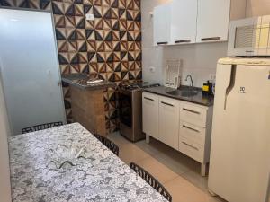 a kitchen with a refrigerator and a table in it at Sobrado encantador no centro, ar cond e vaga in Ourinhos