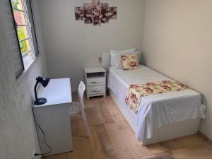 a small bedroom with a bed and a desk at Sobrado encantador no centro, ar cond e vaga in Ourinhos