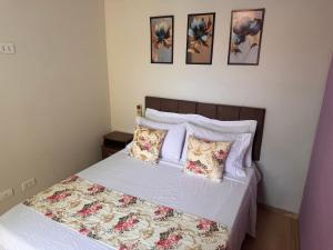 a bedroom with a bed with flowers on it at Sobrado encantador no centro, ar cond e vaga in Ourinhos +13 photos