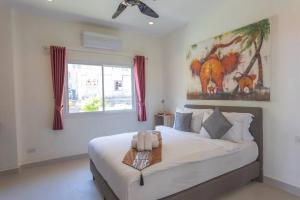 une chambre avec un lit et un tableau au mur dans l'établissement Luxury Seaview Villa, Infinity Pool, Sunset, à Karon Beach 14 autres photos