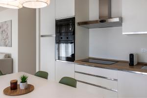 a kitchen with a white counter top and a table at Casa Vistalago Mountain Lake Iseo Hospitality in Bossico +6 photos