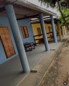 a building with blue columns and a door at Recanto Monte das Oliveiras Hotel e Pousada in Tupim