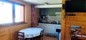 a small kitchen with a table and a window at Appartement de la Fruitière in Arith
