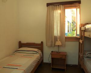 een kleine slaapkamer met een bed en een raam bij LalomitaGesell in Villa Gesell