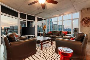a living room with leather furniture and a flat screen tv at The Gallery Loft - Downtown finest in San Diego +45 photos