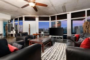 un soggiorno con mobili in pelle e una TV a schermo piatto di The Gallery Loft - Downtown finest a San Diego