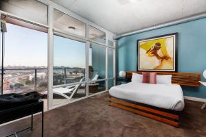 a bedroom with blue walls and a bed and windows at The Gallery Loft - Downtown finest in San Diego