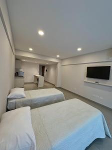 a bedroom with two beds and a flat screen tv at Otero Coliving - Studio Entero U1 in San Salvador de Jujuy