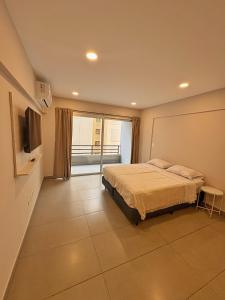 a bedroom with a bed and a flat screen tv at Otero Coliving - Studio Entero U1 in San Salvador de Jujuy