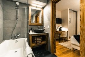 a bathroom with a bath tub and a sink at Centre Les Gets with 2 parking and Slope views - 6&2 ppl - Asteria in Les Gets +23 photos
