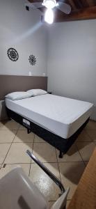 a bed in a room with a white mattress at Bertioga litoral in Bertioga