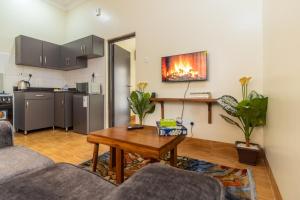 a living room with a table and a kitchen at Riverside Suites Buwate in Kampala