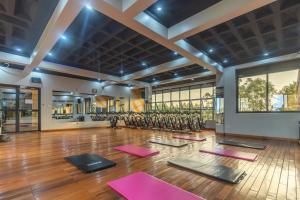 a yoga class in a large room with pink yoga mats at Riverside Suites Buwate in Kampala