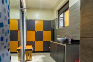 a bathroom with yellow and black dividers and a sink at Riverside Suites Buwate in Kampala +122 photos