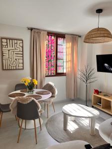 a living room with a table and chairs at Buganvilla Garden Puerto de la Cruz in Puerto de la Cruz