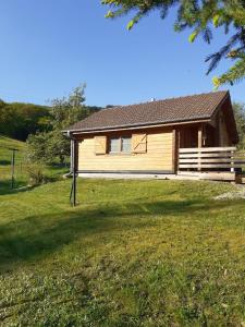 a house on a grassy field with a building at Chalet L' Aventurière in Masevaux