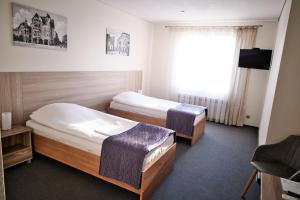 a hotel room with two beds and a window at Restauracja Stylowa in Ostrów Wielkopolski