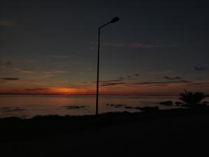 a street light on the beach at sunset at Sun N Sand in Ligia