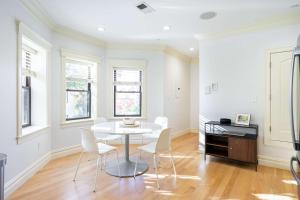 a white dining room with a table and chairs at Brownstone Luxury Penthouse Condo in Boston
