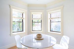 a white dining room with a white table and chairs at Brownstone Luxury Penthouse Condo in Boston
