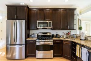 a kitchen with wooden cabinets and stainless steel appliances at Brownstone Luxury Penthouse Condo in Boston