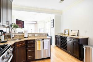a kitchen with wooden cabinets and stainless steel appliances at Brownstone Luxury Penthouse Condo in Boston