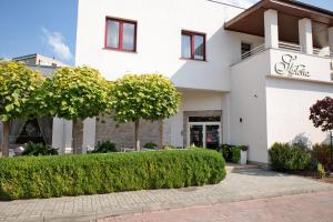 a white building with a hedge in front of it at Restauracja Stylowa in Ostrów Wielkopolski +27 photos