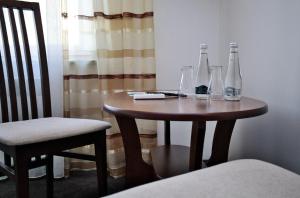a small table with two bottles and glasses on it at Restauracja Stylowa in Ostrów Wielkopolski