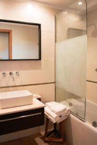 a bathroom with a sink and a shower at Las Bayas Home Suites in Esquel