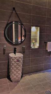 a bathroom with a toilet and a round mirror at شاليهات سمو بارك 1 in Taif +12 photos