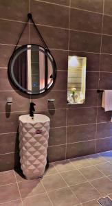 a bathroom with a toilet and a round mirror at شاليهات سمو بارك 1 in Taif +12 photos