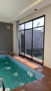 Un jacuzzi en una habitación con una ventana grande. en شاليهات سمو بارك 1, en Taif