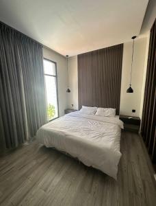 Un dormitorio con una cama blanca y una ventana. en شاليهات سمو بارك 1, en Taif