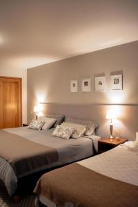 a hotel room with two beds and two lamps at Las Bayas Home Suites in Esquel