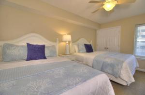 a bedroom with two beds and a ceiling fan at Crescent Shores South - 510 in Myrtle Beach +28 photos