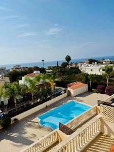 a view of a swimming pool from a balcony at Sea View Family Apartment with Pool in Kissonerga