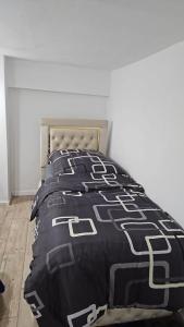 ein Schlafzimmer mit einem Bett mit einer schwarz-weißen Bettdecke in der Unterkunft Natur Atmosphäre in Netphen